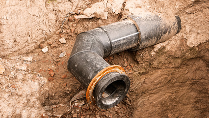 Ditch with open modern PVC water large diameter pipe in its side