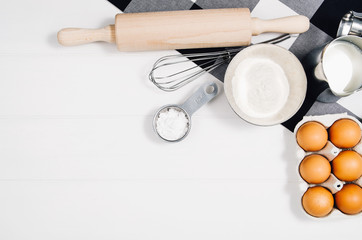 Baking a cake or pizza ingredients background. Top view photograph with kitchen utensils on vintage, natural, white, wooden background.