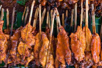 marinated grilled chicken sticks on banana leaves