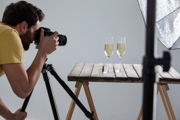 Male photographer photographing champagne glasses