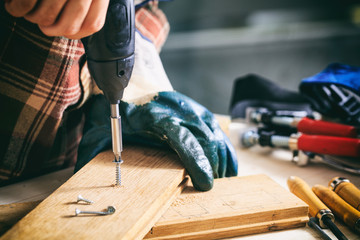 Carpenter working with an electric screwdriver - obrazy, fototapety, plakaty