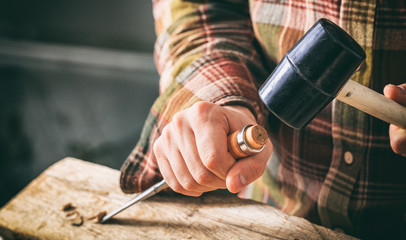 Carpenter working with a chisel - obrazy, fototapety, plakaty