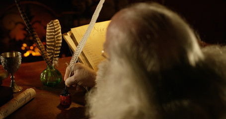 Santa writing with a feather quill