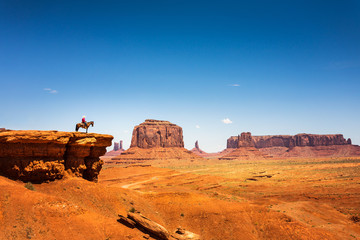 Rider on a horse at the top of sandstone mountain