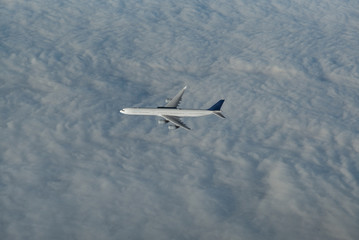 vierstrahliges Passagierflugzeug im Flug - über den Wolken 