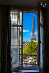 The Eiffel Tower framed through an open window in Paris, France