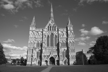 Black and white image of Salisbury Cathedral which has the tallest church spire in the UK photographed on a sunny day. With space for text.