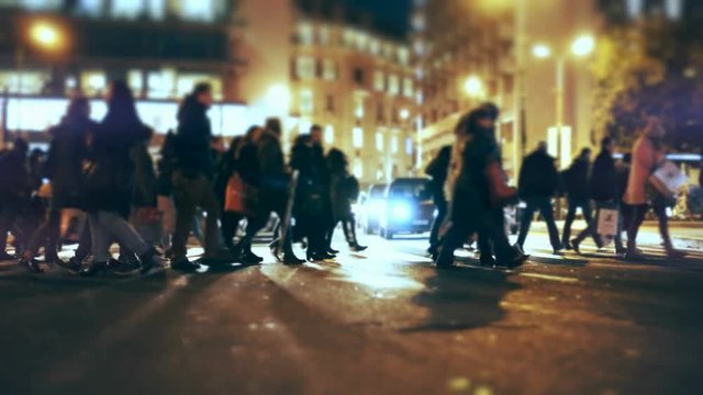 4K City pedestrians cross busy street intersection.4K UHD Gimbal stabilized tracking shot of an anonymous crowd of pedestrians  walking/crossing a busy city street at night.No logos or faces visible.
