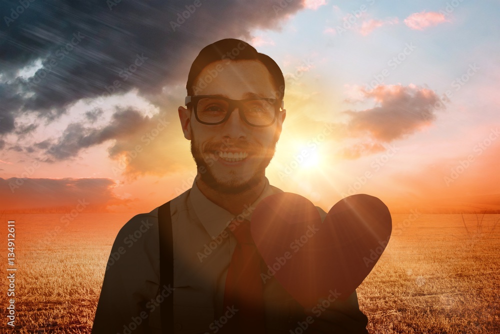 Poster composite image of geeky hipster smiling and holding heart card