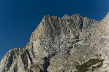 Towering granite peaks rise above a deep forested alpine valley in California's high sierra
