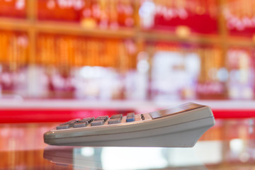 Old big calculator on the mirror in red shop blurr background