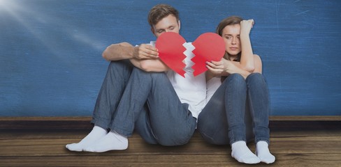 Composite image of young couple holding broken heart