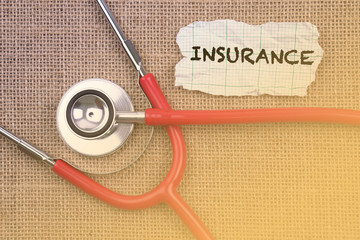 Stethoscope and paper with word insurance. Medical Concept