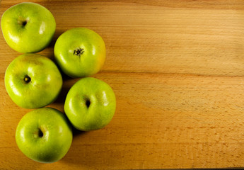 Fresh green apples on wooden background