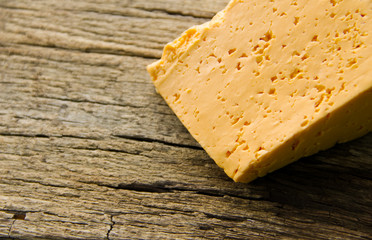 Piece of cheese on a wooden background