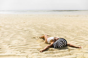 Fototapeta na wymiar a young woman lying on the sand