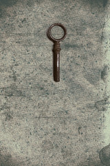 Old key on the old textured paper with natural patterns