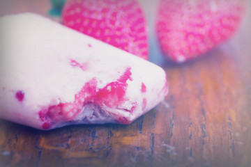 Obraz na płótnie Canvas Homemade strawberry ice lolly on rustic background
