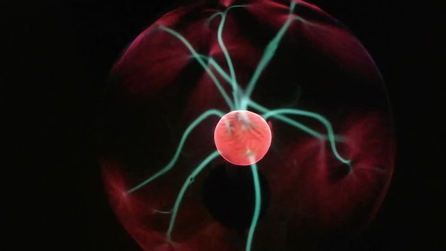Plasma ball with moving energy rays inside on black background