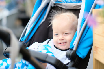 Fototapeta na wymiar Baby boy sitting in modern stroller