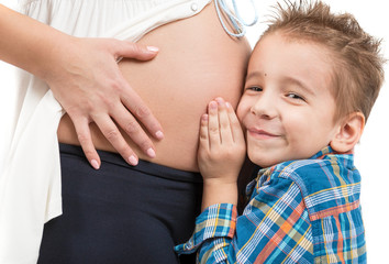 Portrait of a child and a pregnant woman. The listens to what is going on in my mother's belly. Photo closeup