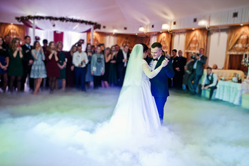 First wedding dance of newlyweds on heavy smoke.