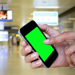 Man hand holding and using mobile,cell phone,smart phone with isolated screen with blurred of corridor inside the metro station.