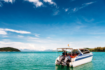 Speed boat in tropical sea. Island on the background.