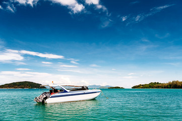 Speed boat in tropical sea. Island on the background.