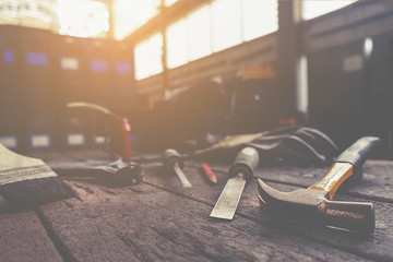 Tools in workshop desk with man working background.