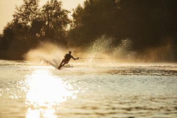 Man riding wakeboard on lake water
