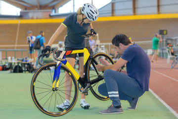 Coach working on cyclist's bicycle