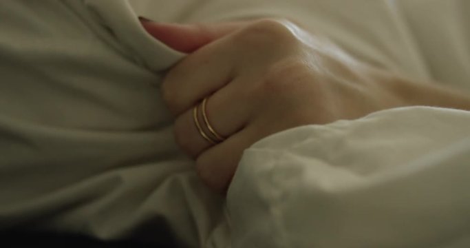 Woman grabs pillow, close up of hand