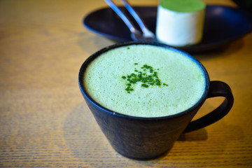 Hot green tea matcha latte on wooden