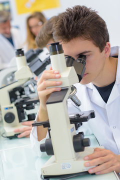 young man looking at a microscope