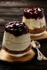 Cheesecake with cherry jelly in glass jars.