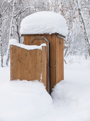 Public toilet, covered with snow in the park