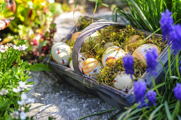 Korb mit Ostereiern im blühenden Garten