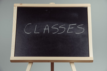 Classes written in white chalk on a black chalkboard