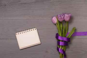 Lilac tulips and banner space for text in the lilac wooden table. Banner template layout mockup for Woman Day, Valentines Day and Teacher's Day. 