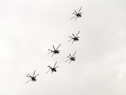 Mil Mi-28 (Havoc) attack helicopters fly in arrow formation against cloudy sky background