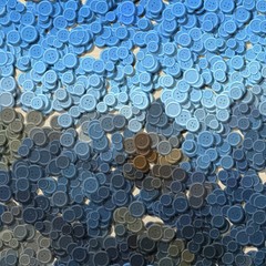 a lot of blue and gray multi colored vintage clothing plastic buttons randomly scattered on the light woody background - top view