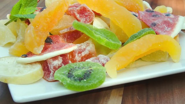Plate of nuts and candied fruit kiwi, orange, watermelon, mango and pineapple