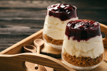 Cheesecake with cherry jelly in glass jars.