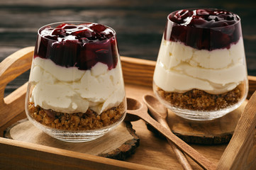 Cheesecake with cherry jelly in glass jars.