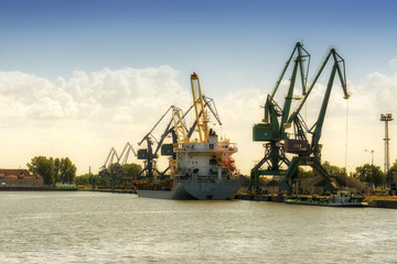 Fototapeta na wymiar 2016-07-21 port of Gdansk, Poland, many cranes on background, working people, sun rest