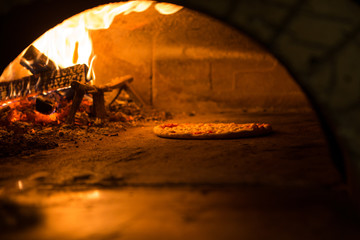 Pizza cucinata in forno tradizionale a legna 