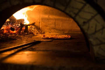 Foto auf Acrylglas Pizzeria Pizza im traditionellen Holzofen zubereitet