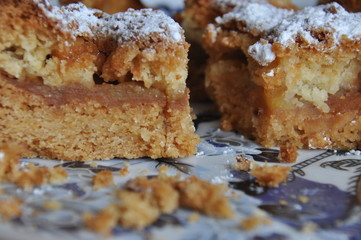 Apple pie dusted with icing sugar on the kitchen table.