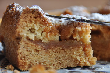 Apple pie dusted with icing sugar on the kitchen table.